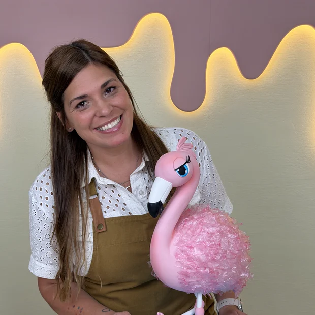 Pamela Pastor sonriendo junto al flamenco escultórico de torta terminado
